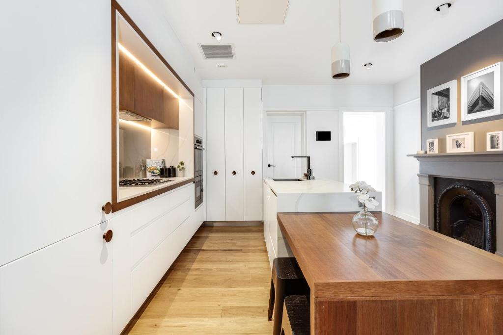 悉尼Barangaroo Park Apartments by Urban Rest的厨房配有木桌和壁炉。
