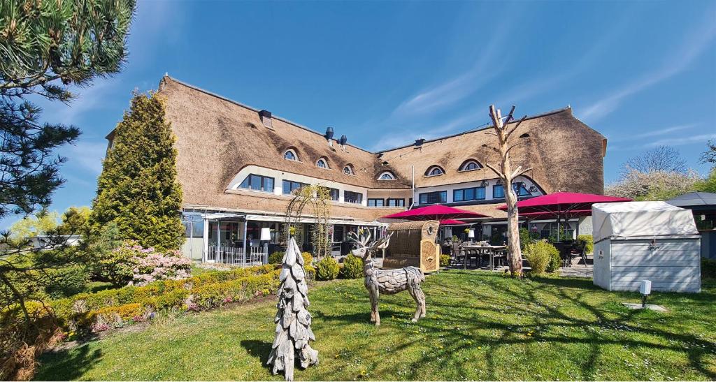 奥斯赛拜-屈隆斯博恩Wittenbeck Resort的一座大砖砌的建筑,在院子里有动物