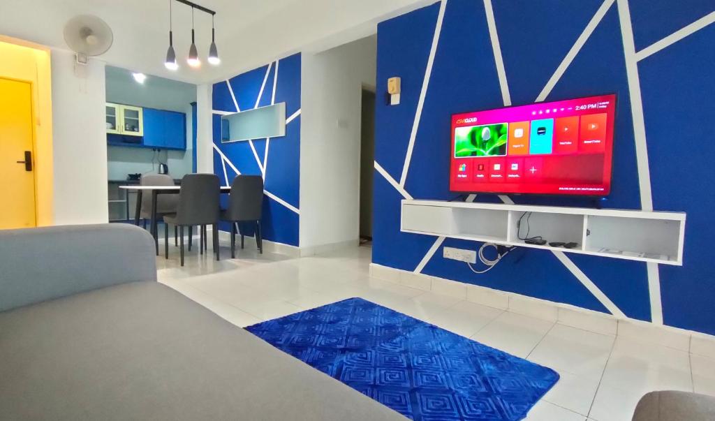 吉隆坡Cozzzzy Two Next to Axiata Arena, Bukit Jalil的一间客厅,客厅的蓝色墙壁上配有电视