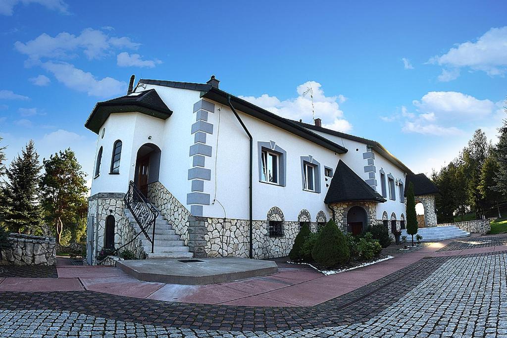 DzibiceZajazd nad Zalewem Dzibice -Pensjonat, Agroturystyka的一条鹅卵石街道上的白色大房子