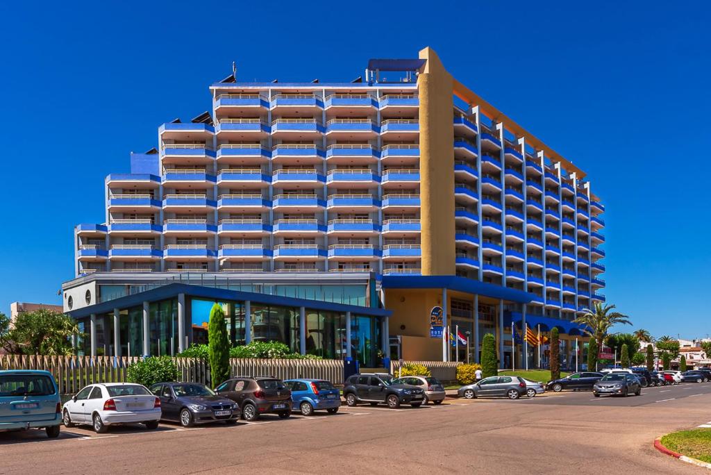 艾姆布里亚布拉瓦科桑斯普拉特哈酒店公寓的停车场内停放汽车的大型建筑