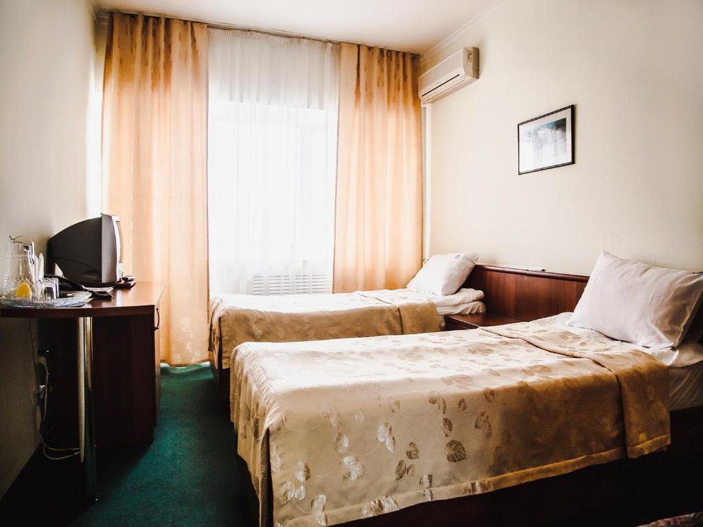 派蒂哥斯卡Yuzhnaya Hotel的酒店客房设有两张床和窗户。