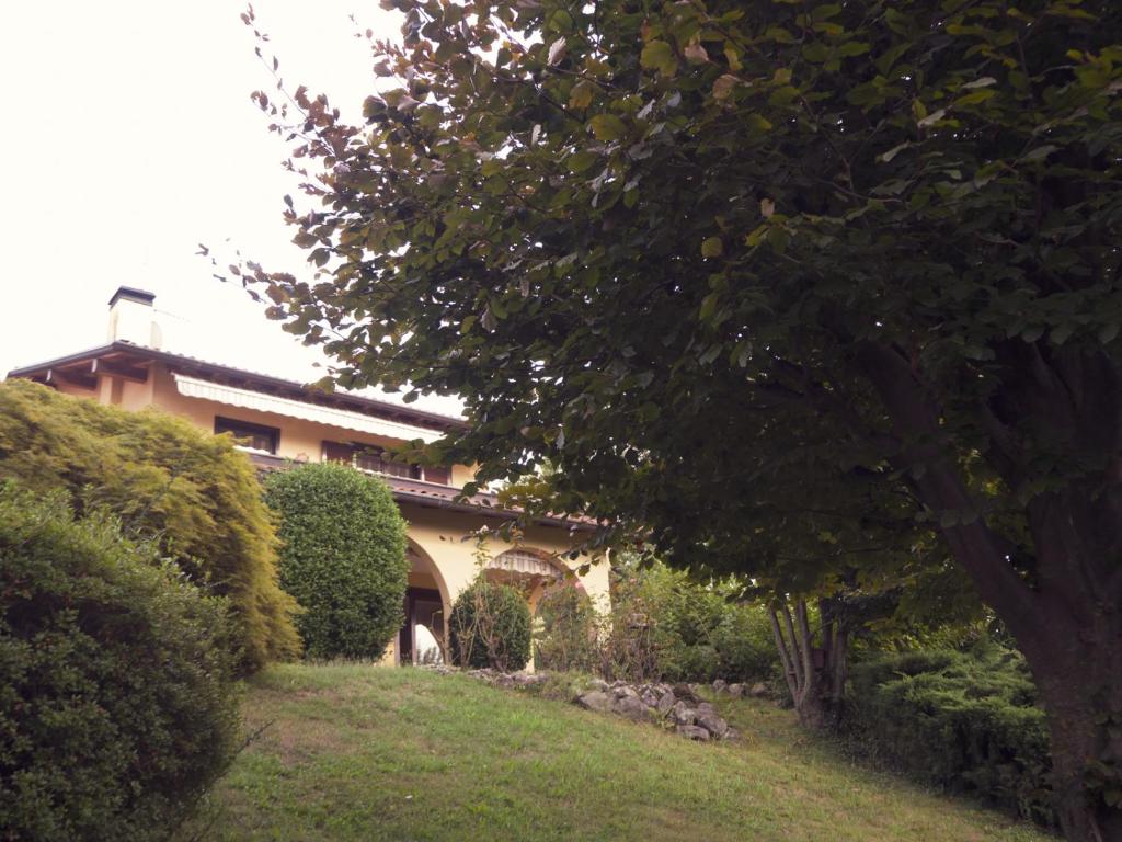 勒威诺Amazing 3 bedrooms villa with lavish garden, breathtaking lake and mountains view的院子前有树的房子