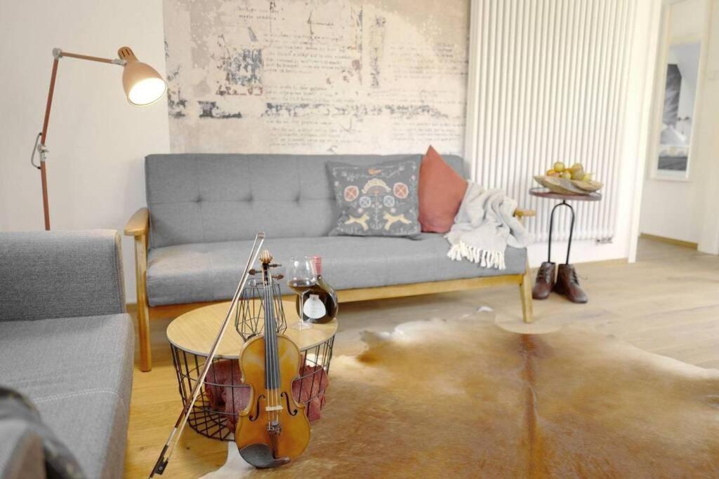 维尔茨堡stilvolle Wohnung direkt in der City的客厅配有蓝色的沙发和小提琴