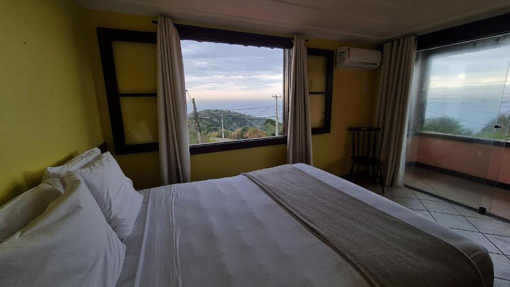 布希奥斯Pousada Mirante dos Papagaios的一间卧室设有一张床和一个大窗户