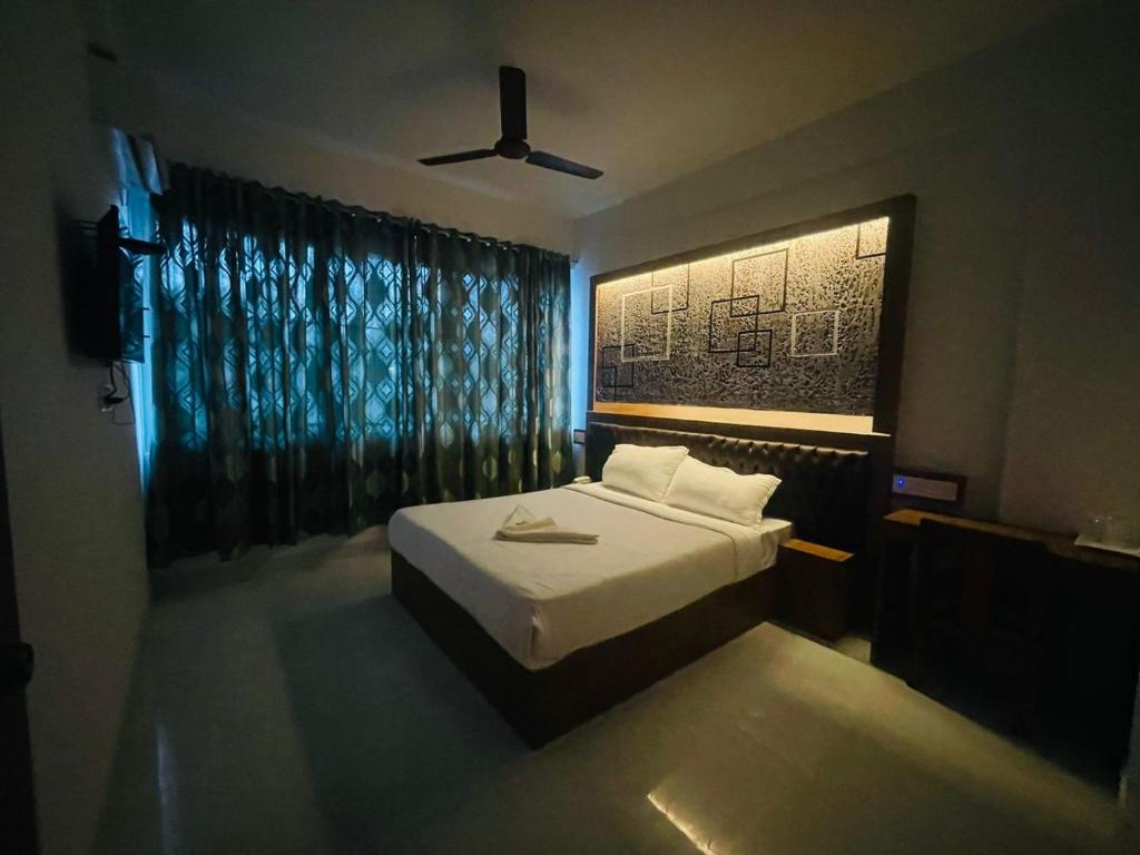 班加罗尔B Six Hotel的一间卧室配有一张床和吊扇