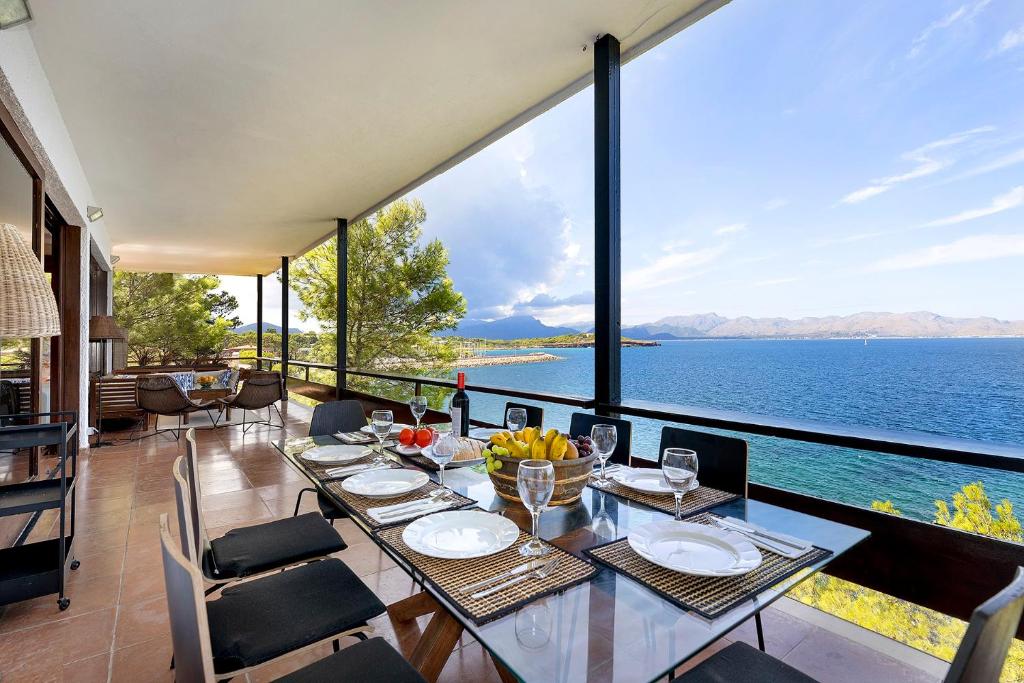 谢洛日博内尔Es Balco, Villa over the mediterranean sea with private beach access的一间配备有桌子的用餐室,享有水景