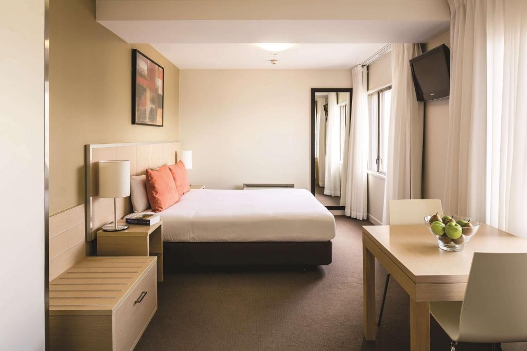 惠灵顿惠灵顿旅客之家酒店的配有一张床和一张书桌的酒店客房