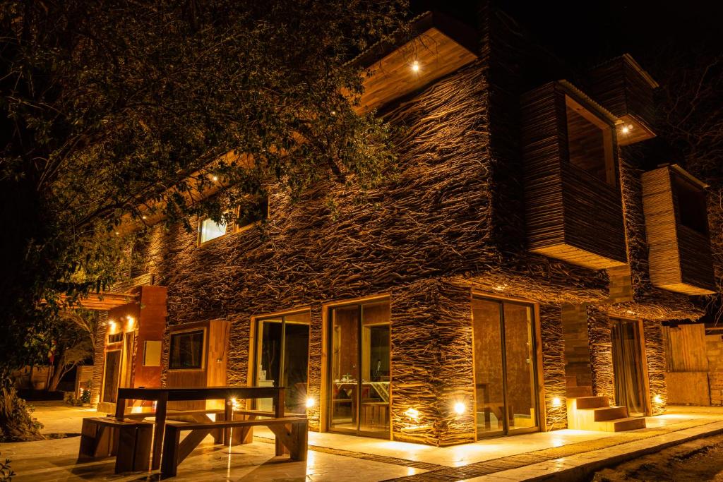 圣佩德罗·德·阿塔卡马Foresta Atacama Lodge的一座在晚上有桌子的建筑