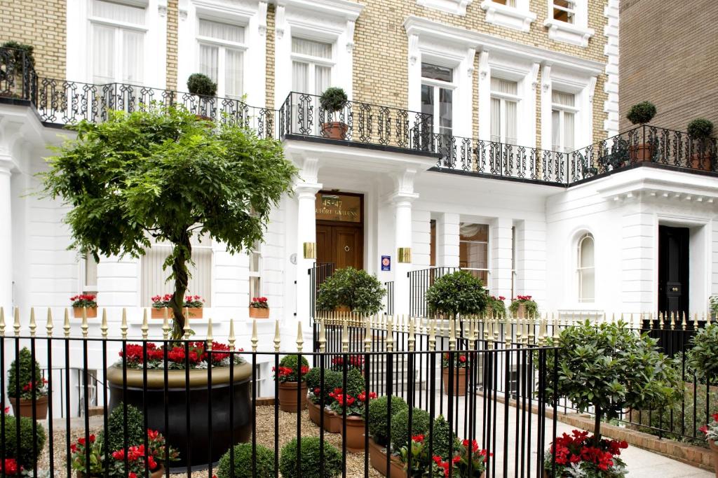 伦敦骑士桥博福特花园公寓的白色的房子,有栅栏和鲜花
