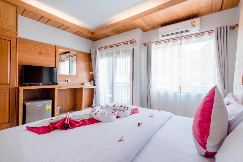 高兰Lanta Ray Bay Hotel的卧室配有带红色枕头的大型白色床