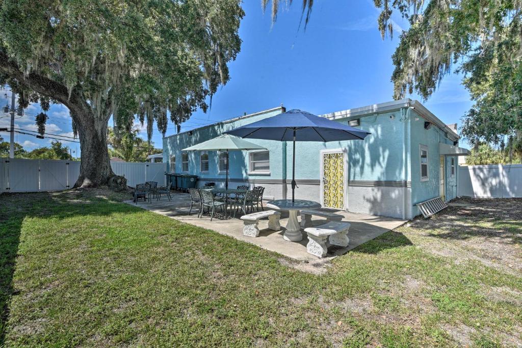 代托纳海滩Serene Daytona Beach House with Private Yard!的蓝色的房子,配有野餐桌和雨伞