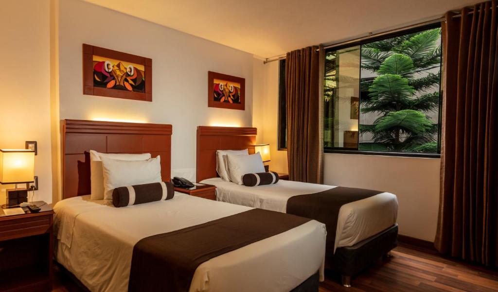 马丘比丘Hotel Ferré Boulevard的酒店客房设有两张床和窗户。