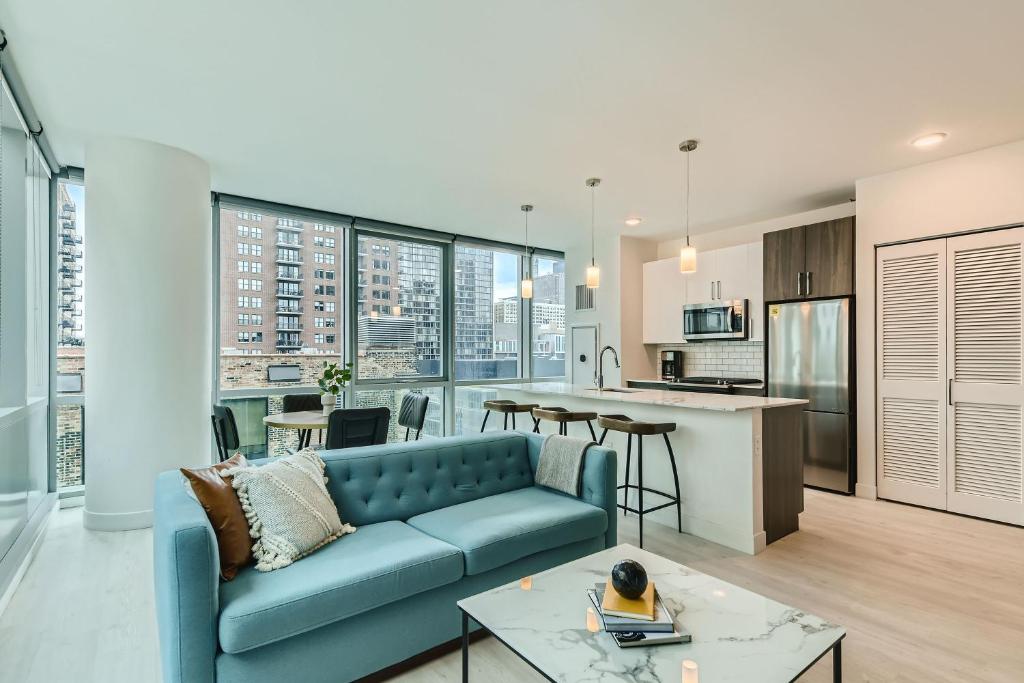 芝加哥Sentral Michigan Avenue的一间带蓝色沙发的客厅和一间厨房