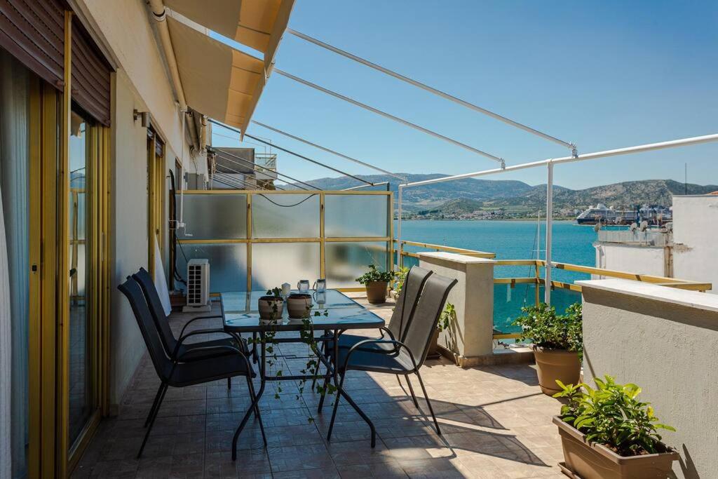 沃洛斯Cozy seaside penthouse with sea & mountain view.的阳台的天井配有桌椅