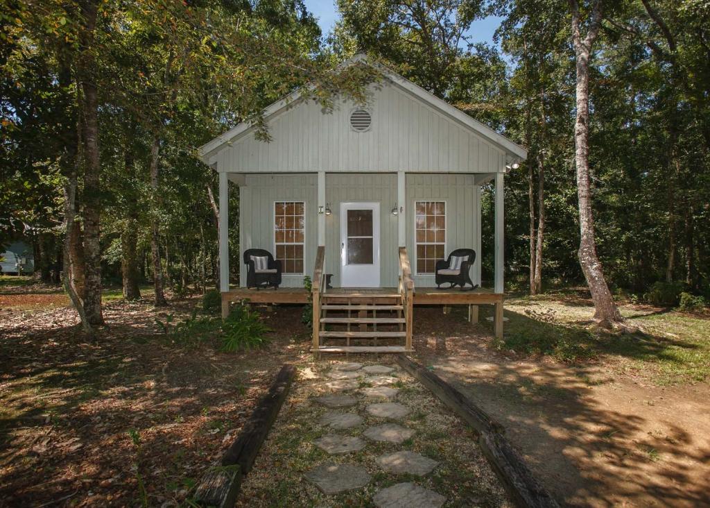 费尔霍普Porch Lane Cottage F的树林中带两把椅子的白色小房子