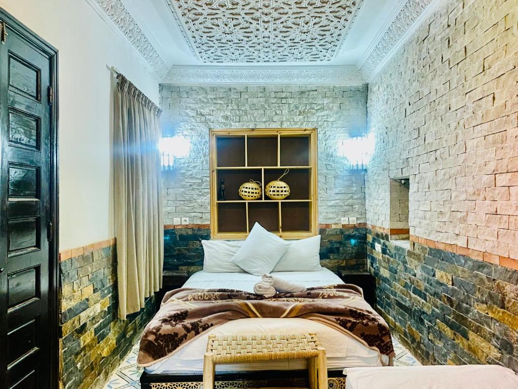 马拉喀什46号摩洛哥传统庭院住宅的一间卧室设有两张床和砖墙