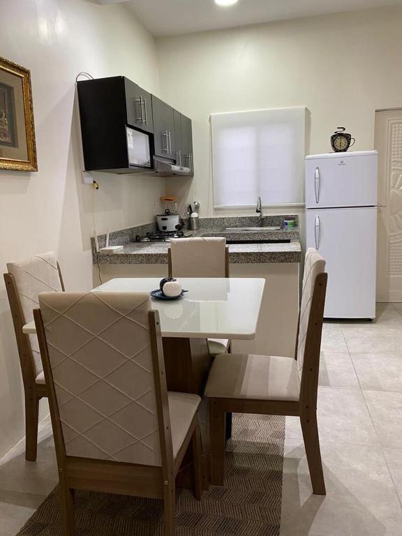 萨利纳斯Villa en Salinas vía Punta Carnero的厨房配有桌椅和白色冰箱。