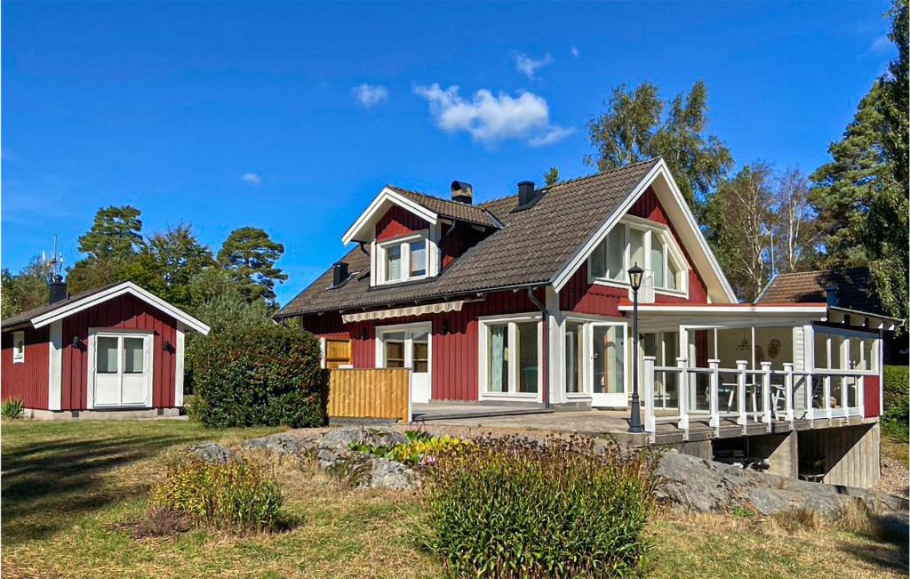 龙讷比Stunning Home In Ronneby With House Sea View的黑色屋顶的红色房子