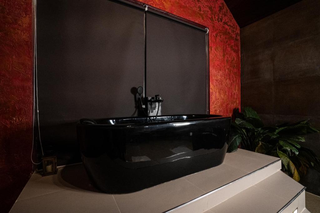努沃勒埃利耶The Edgware Cabana的红色墙壁浴室内的黑色浴缸
