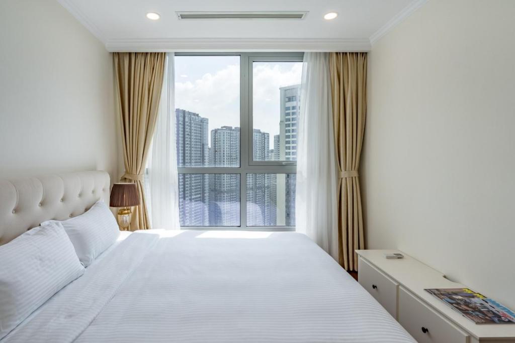 胡志明市Luxury Vinhomes Central Park (Cozy Apartment)的一间卧室设有一张床和一个大窗户