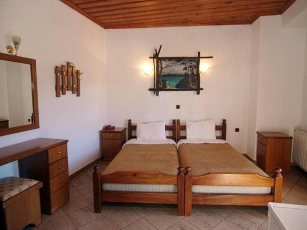 PsarádesArhontiko的一间卧室配有一张床、一个梳妆台和镜子