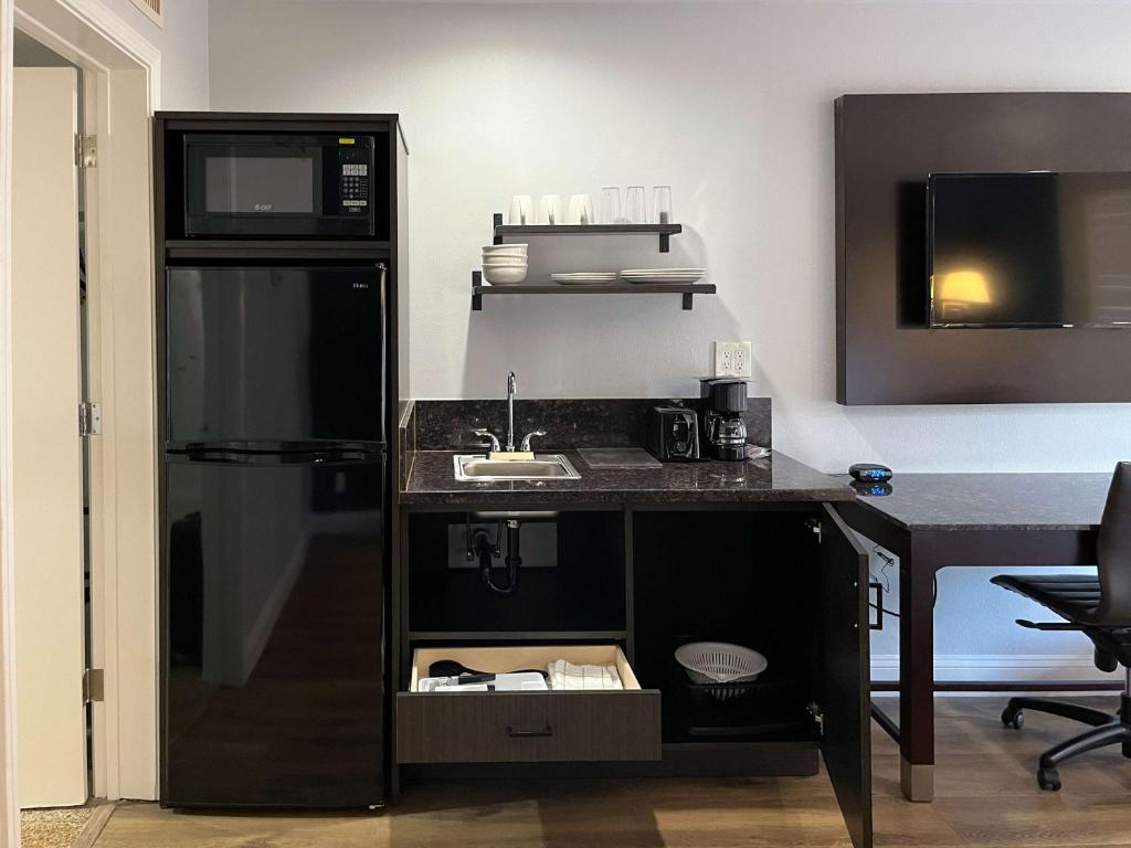 瓦列霍Studio 6 Vallejo CA Napa Valley的厨房配有水槽和黑冰箱。