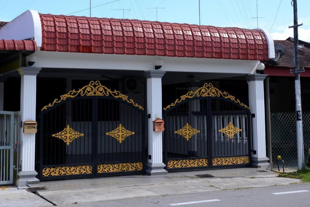 麻坡Wonderful Homestay at Muar的一座拥有金色装饰的黑色大门的建筑