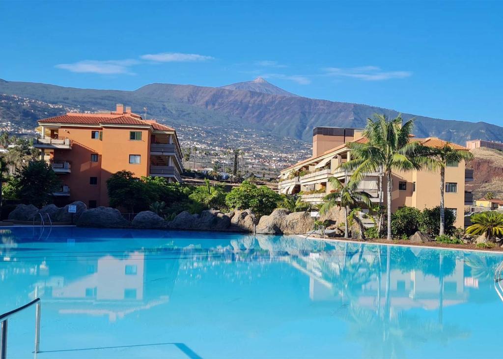 拉克鲁斯Retama del Teide, Puerto de la Cruz的一座大型游泳池,位于部分建筑前