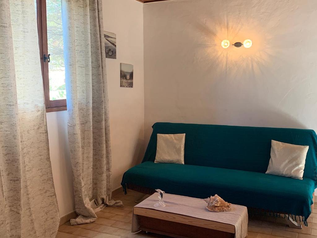 菲加里Gîte à Poggiale de Figari的客厅配有绿色沙发和桌子