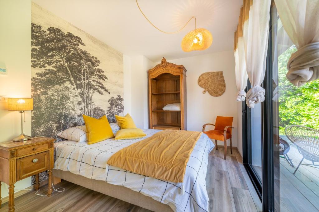 安德诺莱斯贝恩MAISON SWANNEL - Cosy & Spa的一间卧室配有一张带黄色枕头的床和一扇窗户