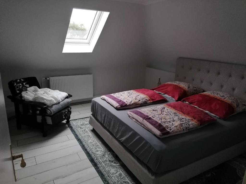 卡斯特罗普-劳克塞尔Haus Lupo am Kanal的一间卧室配有一张带红色枕头的床和一扇窗户