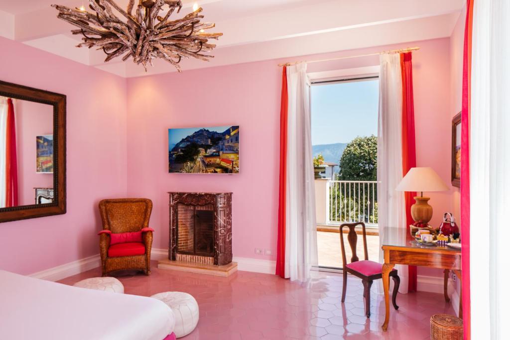 圣安格塔苏德格尔夫顿阿尔丰索1890精品酒店的粉红色的卧室设有一张床和一个壁炉