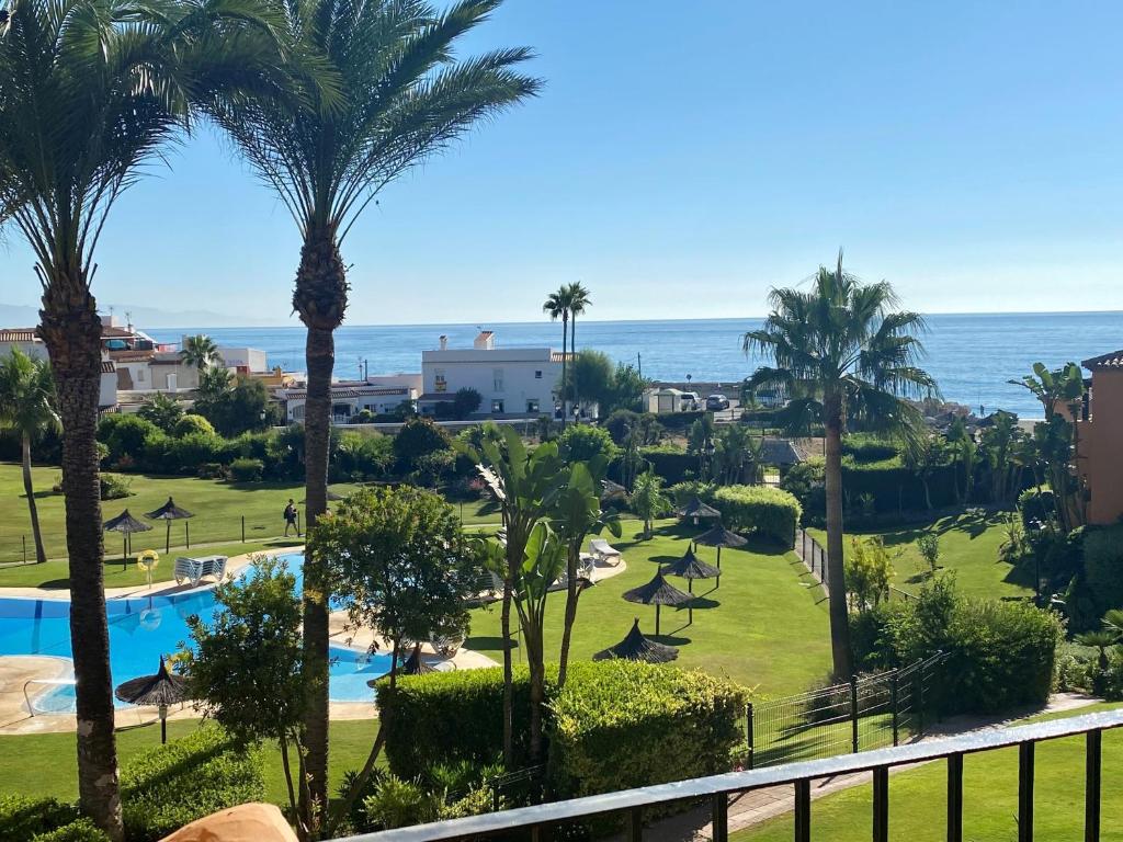 圣路易斯·德·萨比尼尔Los Granados de la Duquesa的从度假村的阳台可欣赏到游泳池和海洋的景色