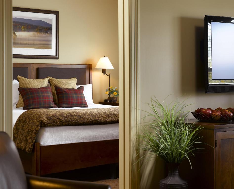 伯灵顿绿山套房酒店的一间卧室配有红色和绿色枕头的床