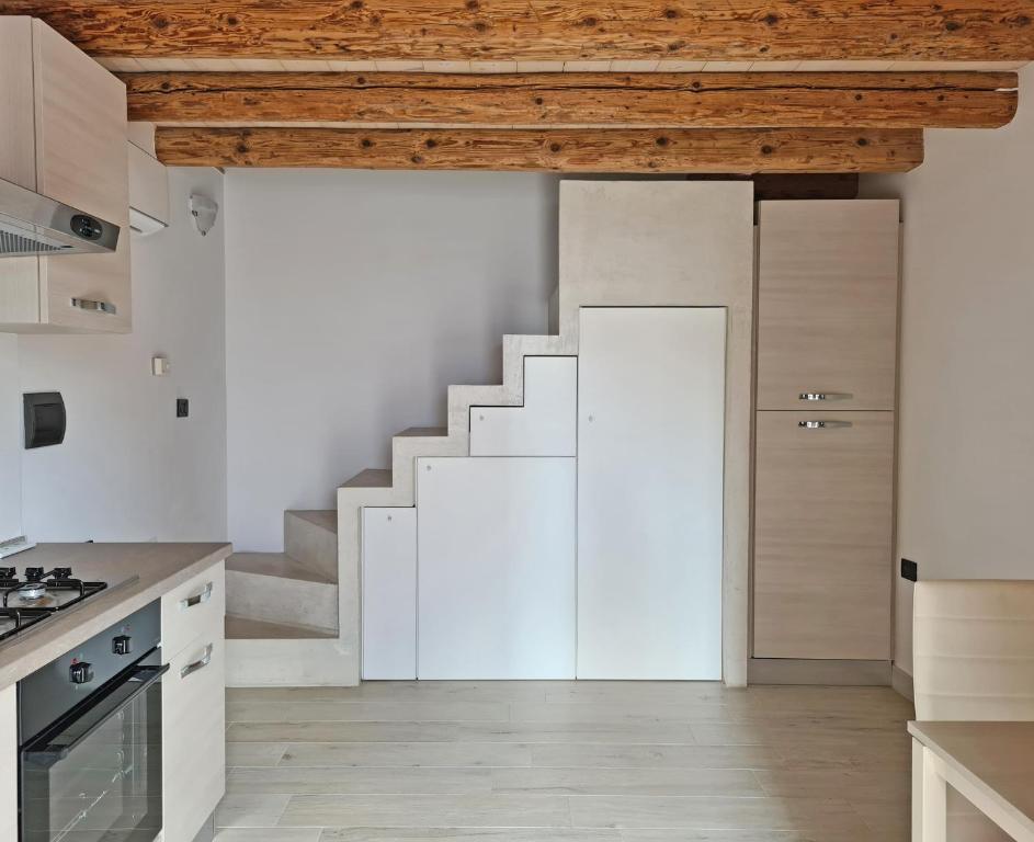 布拉诺岛Ca' Nova - Burano的一间厨房,配有白色橱柜和楼梯