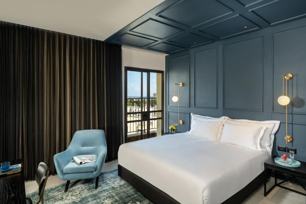 海法Hotel Botanica- Limited Edition By Fattal的一间卧室配有一张床和一张蓝色椅子
