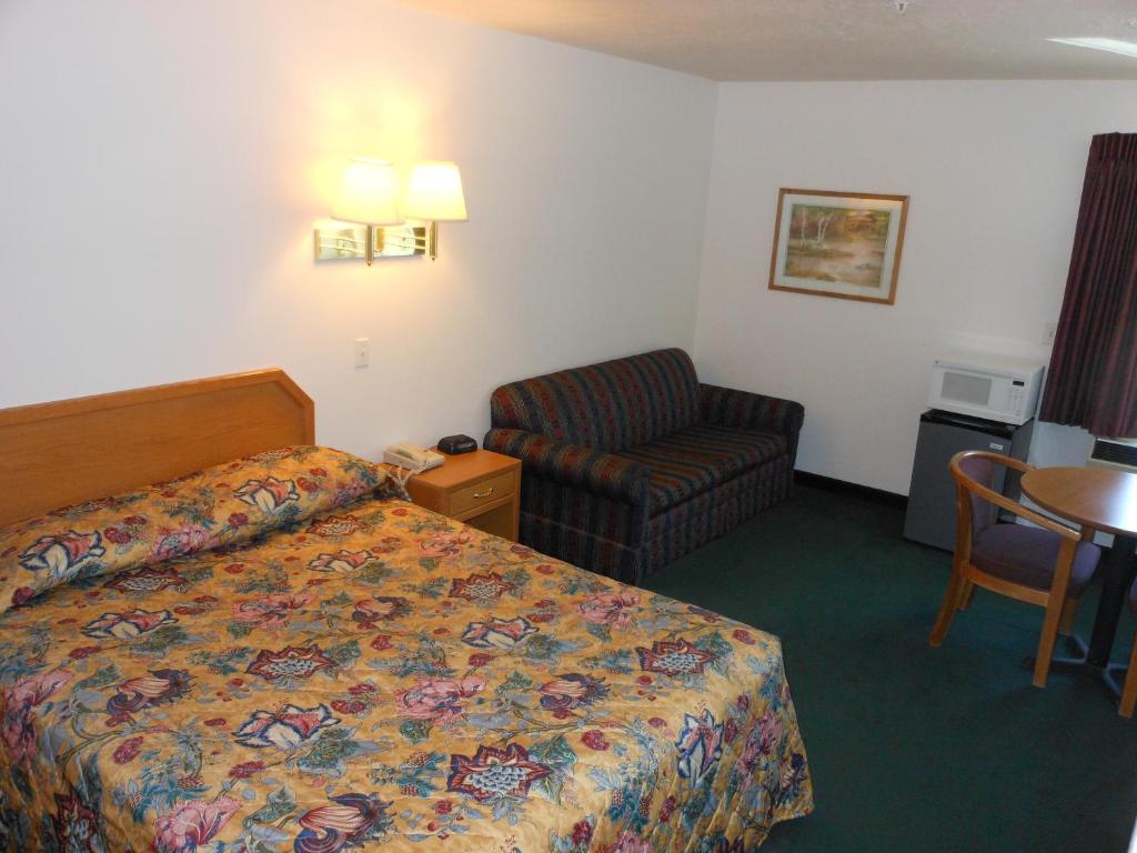 尼法经济套房酒店的配有一张床和一把椅子的酒店客房