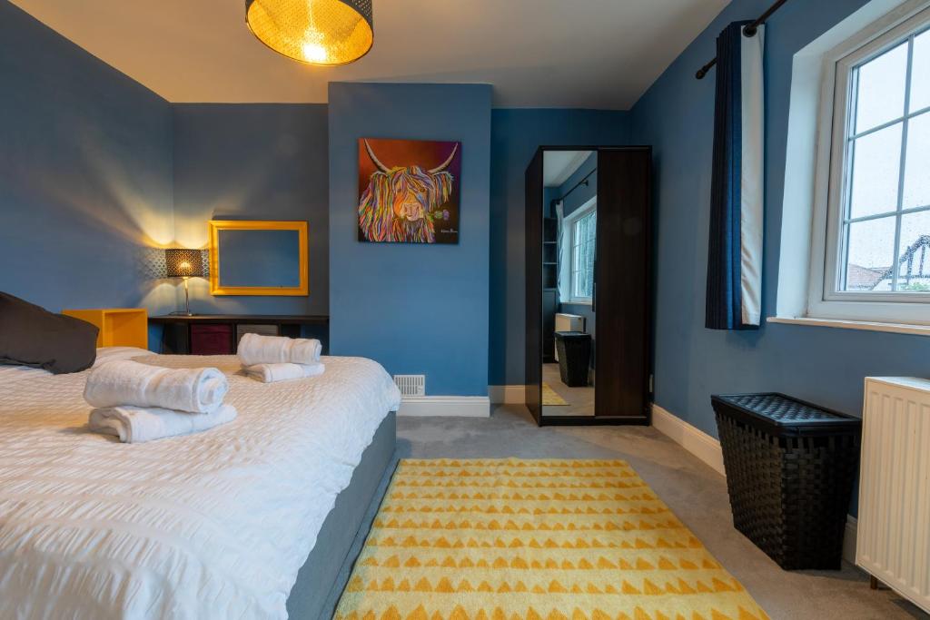布里斯托3 bedroom home and garden in North Bristol的一间卧室拥有蓝色的墙壁,配有一张带白色枕头的床。