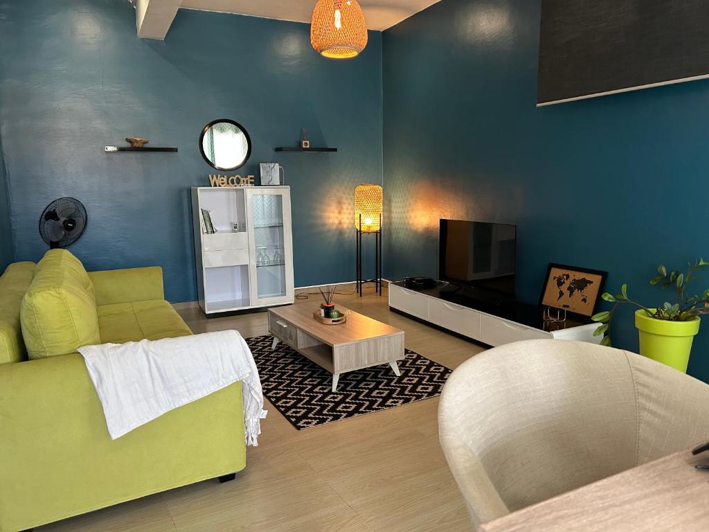 MamoudzouCharmant appartement avec terrasse, vue sur lagon的客厅配有绿色沙发和电视