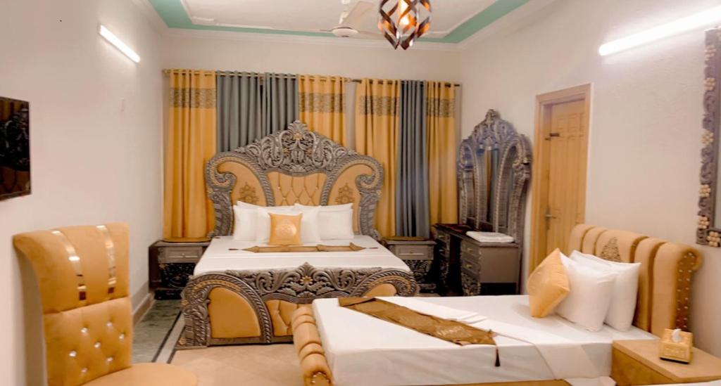 伊斯兰堡Galaxy Lodge的一间卧室配有两张床和一张桌子及椅子