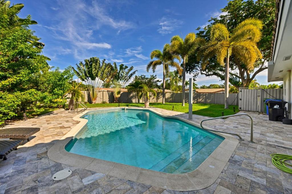 劳德代尔堡Moana Beach Cottage的棕榈树庭院内的游泳池