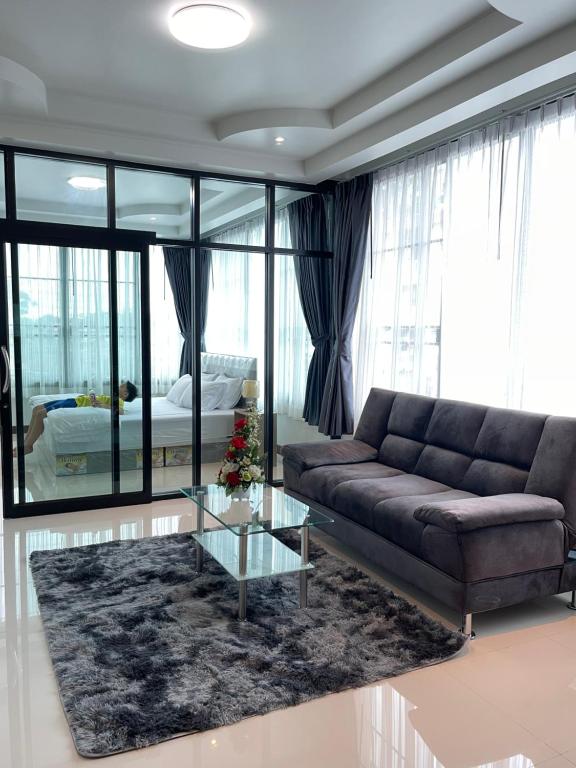 南邦Service Apartment ใจกลางเมืองใกล้แหล่งท่องเที่ยว119ทับ1ถนนปงสนุก的带沙发和玻璃桌的客厅