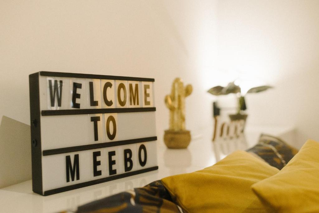 诺维萨德meebo apartments的一张写着欢迎睡床旁边的蜂窝的标志
