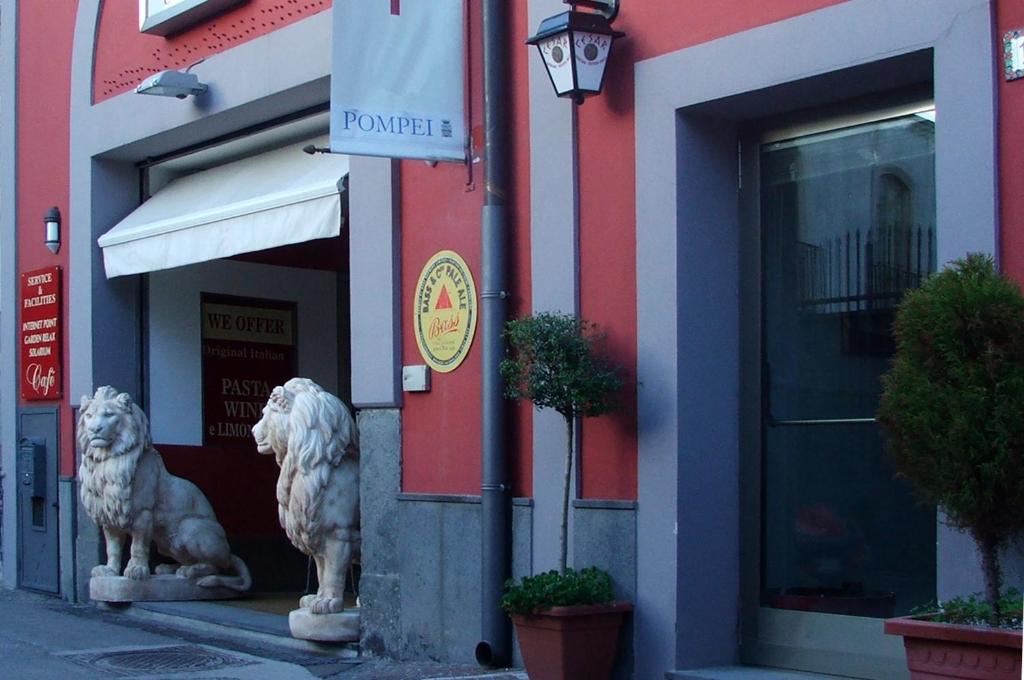 庞贝Agorà Hostel的两座狮子雕像,在一座建筑前