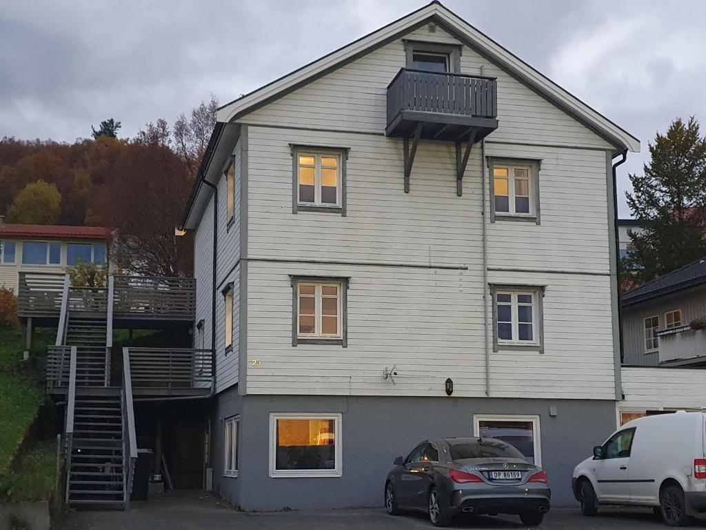 哈尔斯塔Åsveien Apartments.的一座大型白色房子,前面有一辆汽车