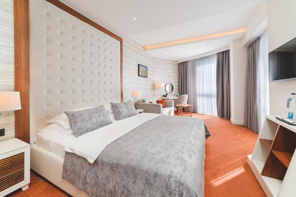 多布拉沃达Kalamper Hotel & Spa的酒店客房设有一张大床和一张书桌。