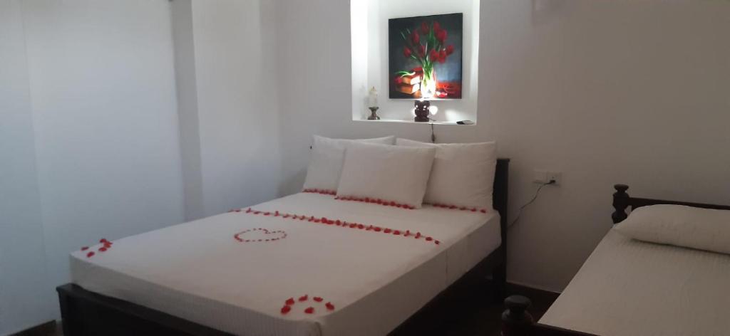 本托塔Sun Kiss lagoon bentota的小卧室配有白色的床,上面有红色的心