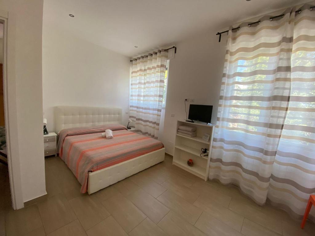 乌尔比诺b&b pellipario的一间卧室配有床、电视和窗帘
