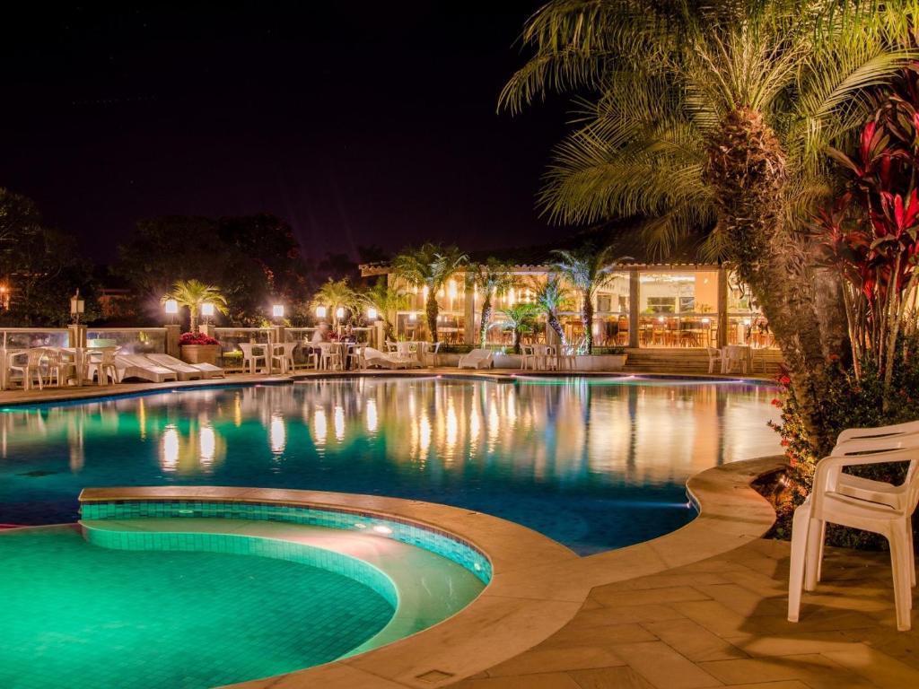 索科罗瑞卡特达卡舒埃拉酒店的游泳池在晚上配有桌椅